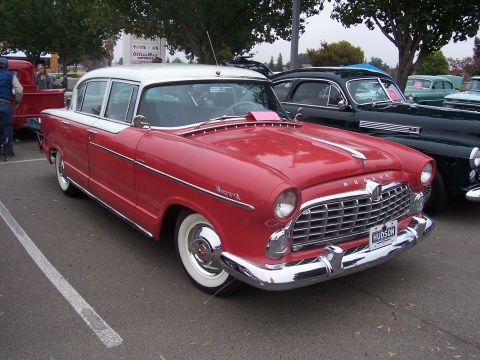 2002 Ford Mustang - A red and white Hudson sedan is parked at an outdoor event, with other vintage vehicles visible in the background.
