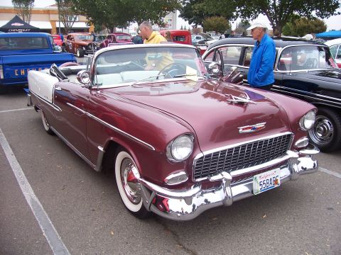2002 Ford Mustang - A classic 1955 Chevrolet Bel Air convertible is displayed at an outdoor event.