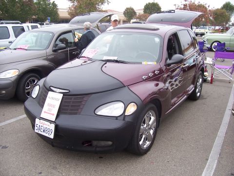 2002 Ford Mustang - A customized Chrysler PT Cruiser is displayed at an outdoor car show with other vehicles present.