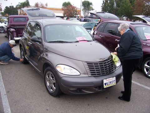 2002 Ford Mustang - A gray Chrysler PT Cruiser is being detailed at an outdoor car event. Multiple vehicles are visible.