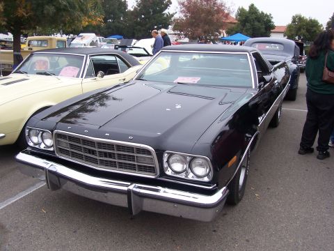 2002 Ford Mustang - Front view of a black 1975 Ford sedan at an outdoor car show.