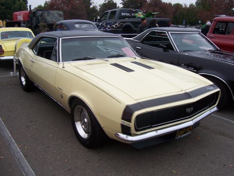 2002 Ford Mustang - A classic Chevrolet Camaro SS is parked in a lot with other vehicles, including a black El Camino.
