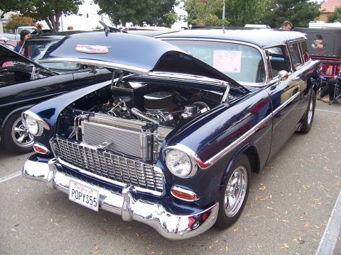 2002 Ford Mustang - A 1955 Chevrolet Nomad station wagon is displayed with its hood open, revealing the engine bay.