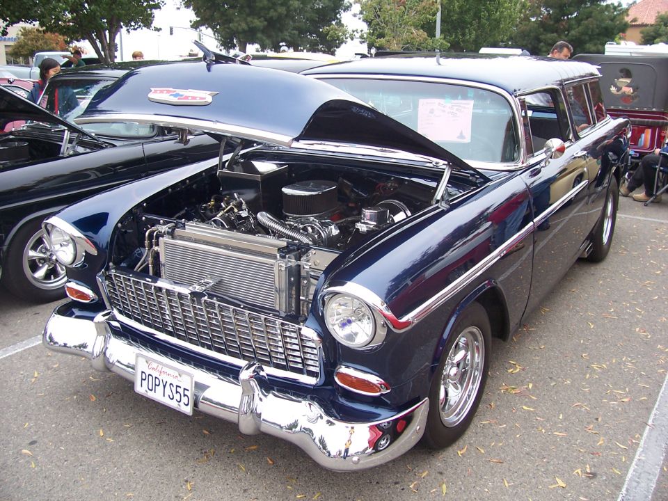 Dark blue 1955 Chevrolet Nomad station wagon with hood open, showing engine. California license plate reads POPY55
