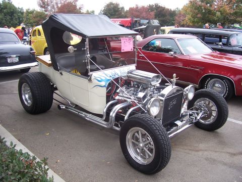 2002 Ford Mustang - A custom hot rod with a powerful engine and flame decals is displayed at an outdoor car show.