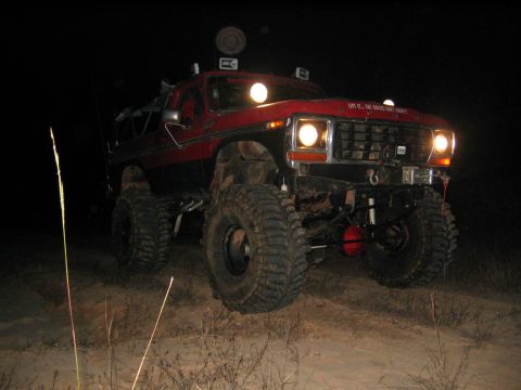 1979 Ford Bronco - This lifted SUV is equipped with large off-road tires and auxiliary lights, ready for nighttime adventures.