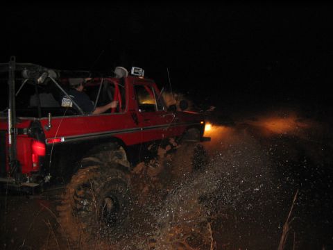1979 Ford Bronco - 1979 Ford Bronco navigating a muddy trail at night.