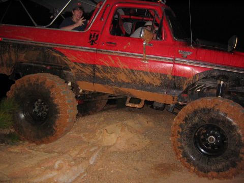 1979 Ford Bronco - Mud-covered 1979 Ford Bronco navigates rough terrain.