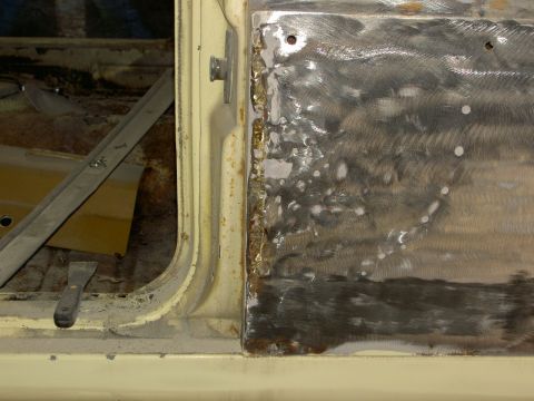 1967 Ford Ranchero - Close-up of a door panel undergoing repair, showing metalwork and rust damage on a 1967 Ford Ranchero.