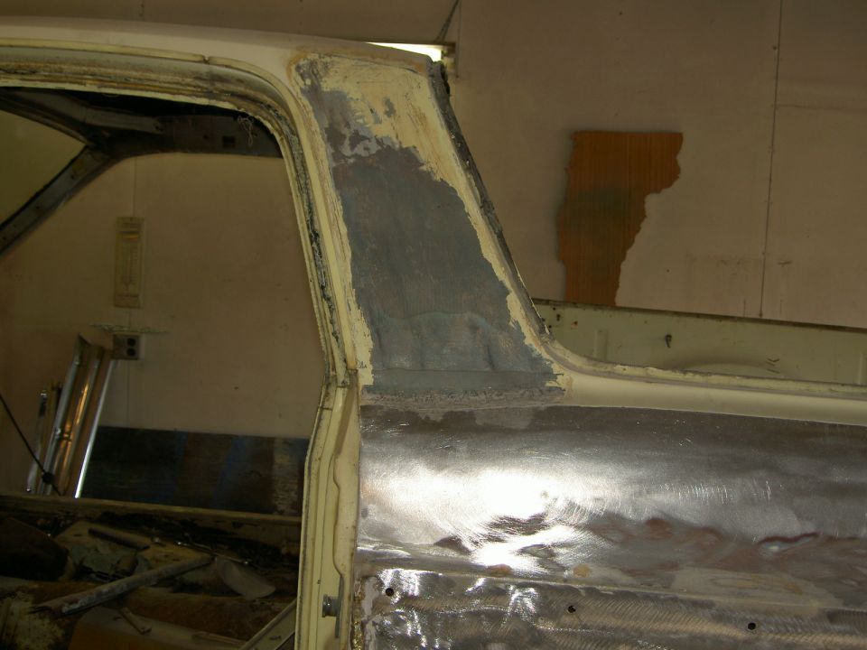 1967 Ford Ranchero door frame with body filler and bare metal patches, viewed from the side