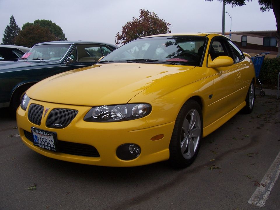 Yellow Pontiac GTO front quarter view, GTO badge on grille, license plate 68563