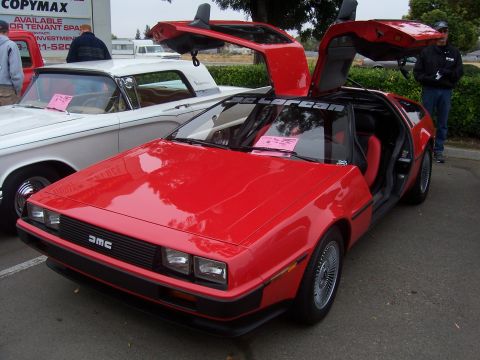 2002 Ford Mustang - A red DeLorean DMC-12 is displayed with its iconic gull-wing doors open.
