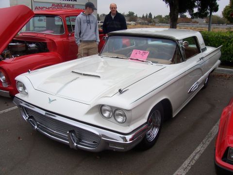 2002 Ford Mustang - A classic white Ford Thunderbird is displayed with its hood up, next to a red pickup truck.
