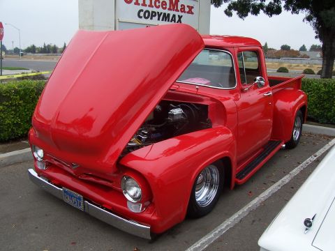 2002 Ford Mustang - This red 1956 Ford F-100 pickup truck is displayed with its hood open, revealing the engine.