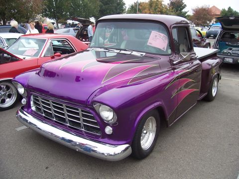 2002 Ford Mustang - A customized pickup truck with flame graphics is parked at an outdoor event.