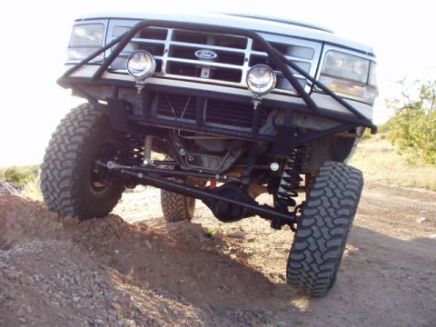 1993 Ford Bronco - This modified Ford Bronco is shown off-road with its front tire elevated on a dirt mound.