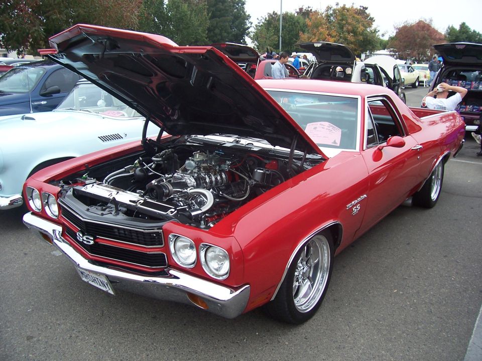 Red El Camino SS with hood open, chrome wheels, SS badging on grille and fender