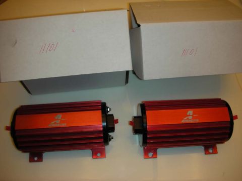 1998 Ford Crown Victoria - pair of red-and-orange Aeromotive inline fuel pumps displayed on a table beside their white shipping boxes.