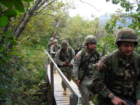 2003 Jeep TJ - Soldiers traverse a wooden bridge during a patrol through a wooded area.