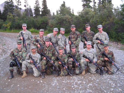 2003 Jeep TJ - A military unit poses for a group photo outdoors, holding their rifles.
