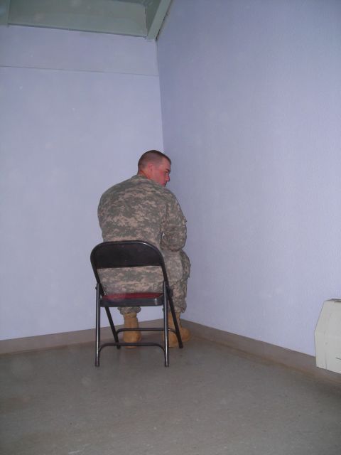 2003 Jeep TJ - A soldier sits in a chair in a sparsely decorated room, looking away from the camera.