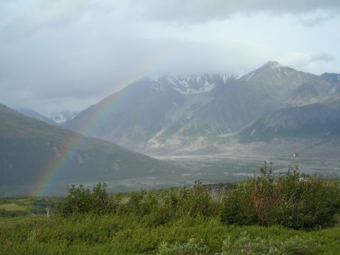 2003 Jeep TJ - A scenic mountain landscape a rainbow after a rain shower, with lush green vegetation in the foreground.