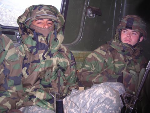 2003 Jeep TJ - Soldiers in camouflage gear are seated inside a military vehicle, appearing to be on duty.
