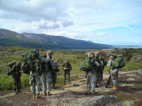 2003 Jeep TJ - Soldiers are gathered in a vast, mountainous terrain, preparing for an expedition.