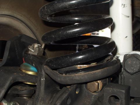 1993 Ford Bronco - A detailed view of a vehicle's suspension system, focusing on the coil spring and associated components.
