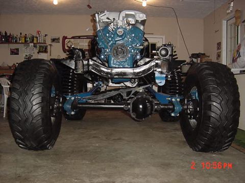 1974 Ford F-100 - The chassis and engine of a custom off-road vehicle are shown in a garage setting.