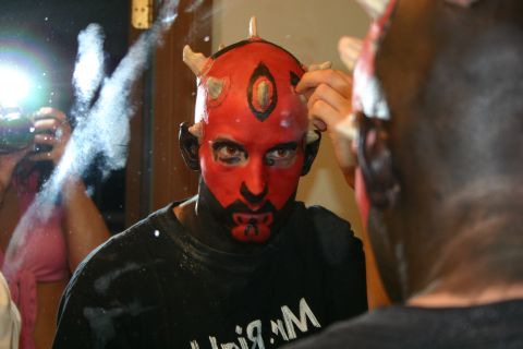 1995 Ford Probe - A person applies face paint in a mirror, preparing for a costume event.