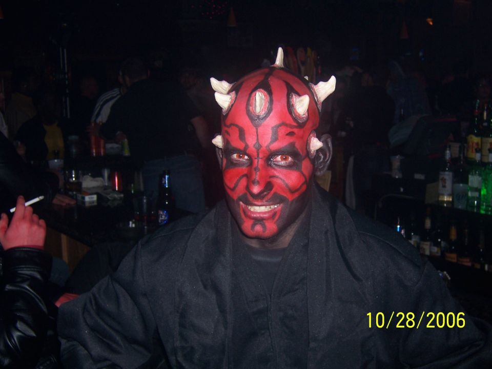 Person in Darth Maul costume at a bar with drinks on shelves in the background