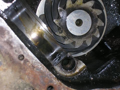 1996 Ford Bronco - A close-up view of a worn engine bearing and a toothed gear assembly, indicating mechanical wear.