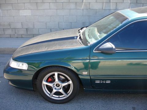 1993 Ford Taurus - This 1993 Ford Taurus SHS features aftermarket wheels and red brake calipers, seen from the front quarter angle.