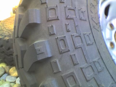 1989 Ford Bronco - The detailed tread pattern of an off-road tire is shown, with visible siping on the blocks.