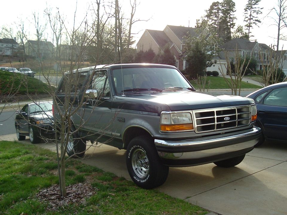 Two-tone Ford F-250 pickup parked in a suburban driveway