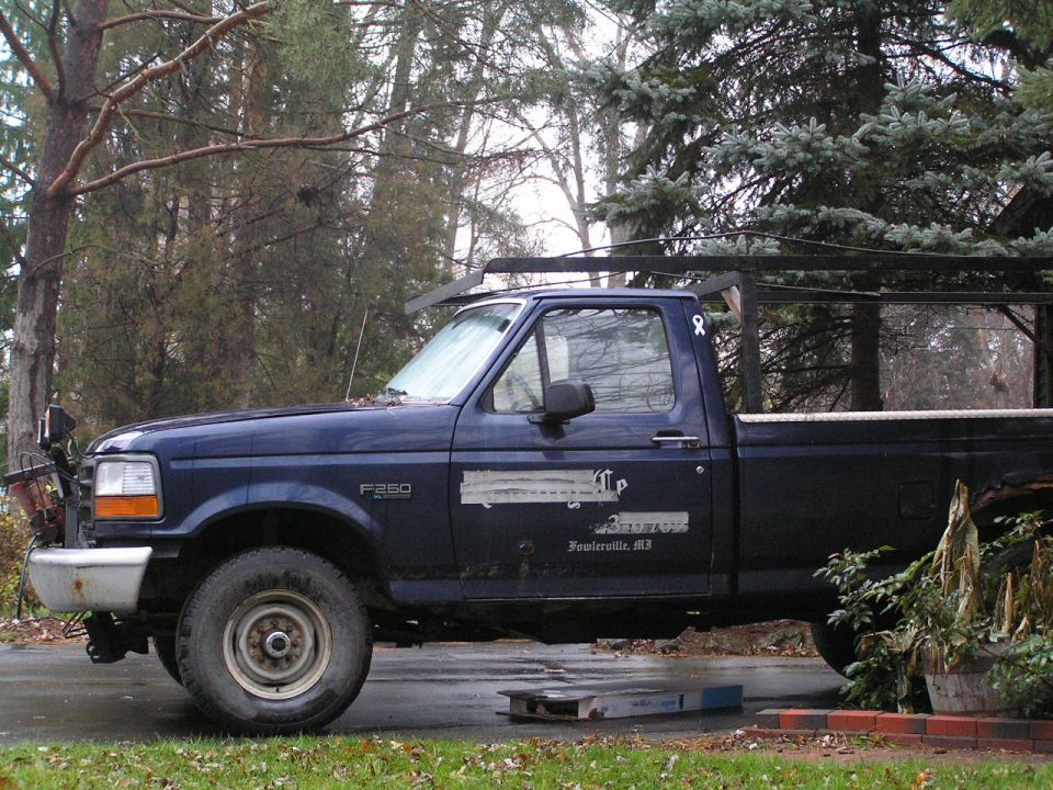 Side view of a blue 1995 Ford F-250 pickup truck with a ladder rack
