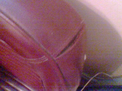 1969 Ford F-250 - Close-up of a car's red painted hood shows a seam and reflection.