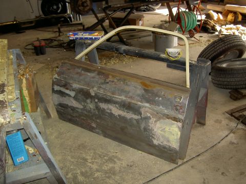 1967 Ford Ranchero - Car door undergoing restoration work in a garage setting, with various tools and parts around.