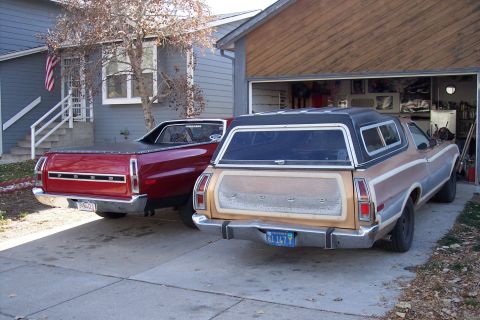 1972 Ford Ranchero - A pair of Ford Rancheros are parked in front of a garage and house. The red vehicle appears to be a 1972 model.