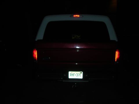 1995 Ford Bronco - Rear view of a 1995 Ford Bronco with a white camper shell and a sticker on the window.