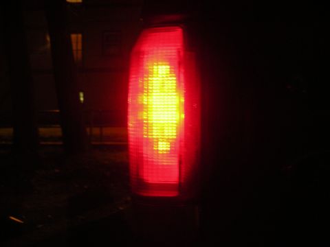 1995 Ford Bronco - Close-up of a vehicle's illuminated taillight against a dark backdrop.