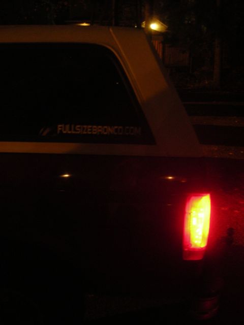 1995 Ford Bronco - Rear view of a 1995 Ford Bronco, showing the taillight and a website sticker on the window.