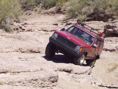 1993 Ford Bronco - This Jeep Cherokee XJ navigates a challenging rocky terrain on an off-road trail.