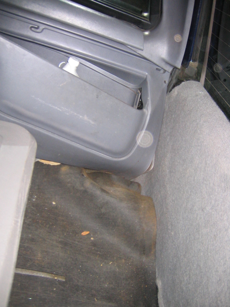 Gray SUV interior door panel and floor with worn carpet