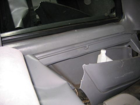 1994 Ford Bronco - Close-up view of the interior door panel and an open storage compartment, revealing a white bottle within.