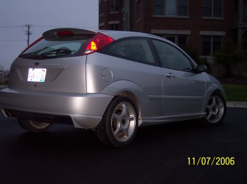 2003 Ford Focus - Rear view of a silver 2003 Ford Focus hatchback parked on asphalt.