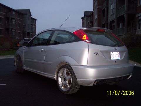 2003 Ford Focus - A silver 2003 Ford Focus SVT hatchback is parked outside apartment buildings.