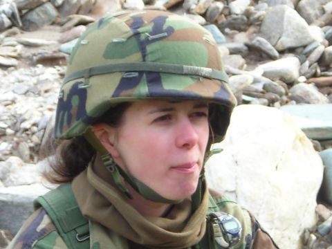 2003 Jeep TJ - A woman wearing a camouflage helmet and military uniform is pictured in a rocky outdoor environment.
