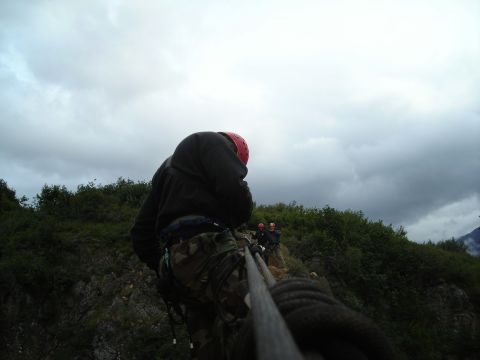 2003 Jeep TJ - Two people are seen on a zipline with a cloudy sky overhead.